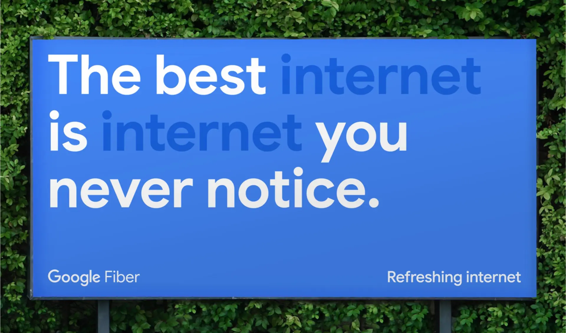 Google Fiber campaign billboard with blue typography, photographed against greenery